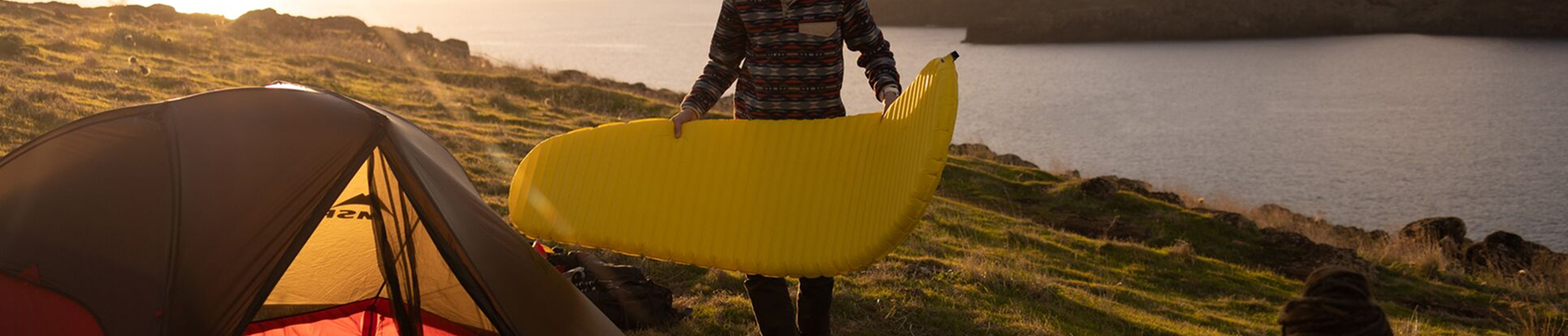 kampeerder maakt zijn slaapmat klaar voor de nacht