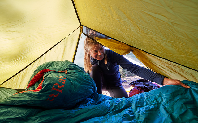 vrouw legt haar slaapzak klaar voor de nacht